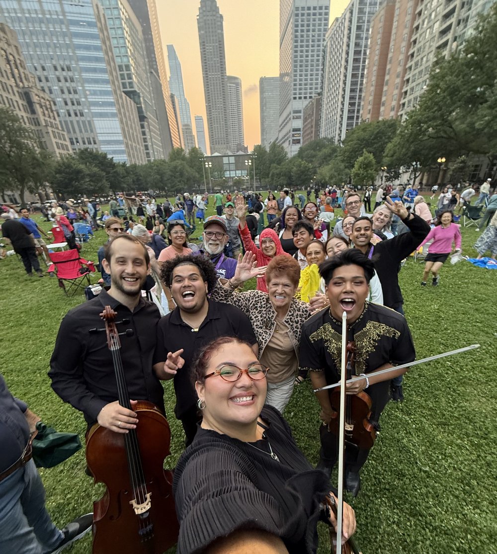 A selfie with instrumentalists and audience with a skyline background