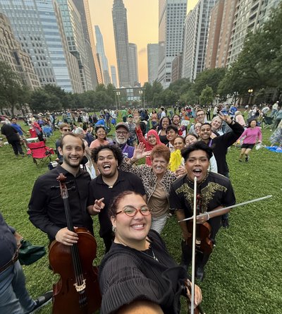 A selfie with instrumentalists and audience with a skyline background