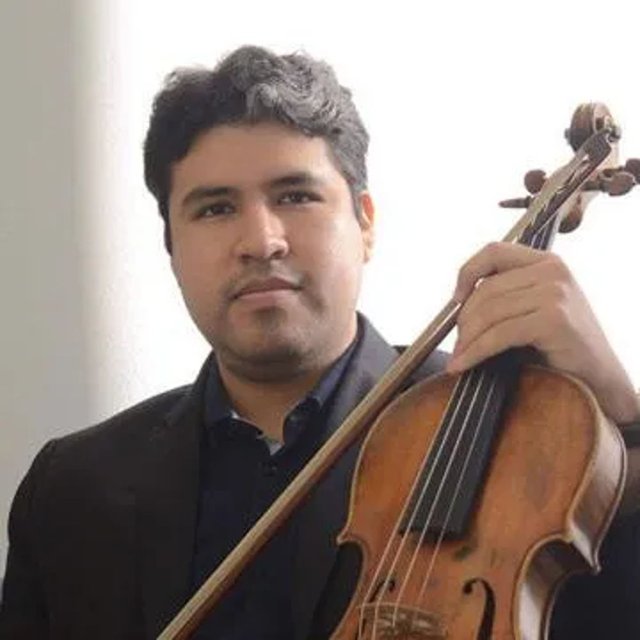 A man with mid-toned skin, wearing a dark suit and holding a viola.