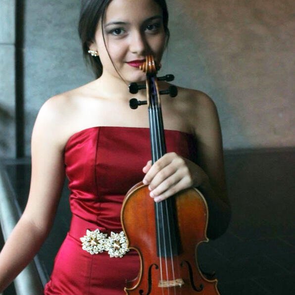 A young woman in a strapless red dress stands with her violin