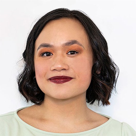 A headshot of a Chinese-American woman with dark red lipstick and a bob haircut, smiling at the camera.